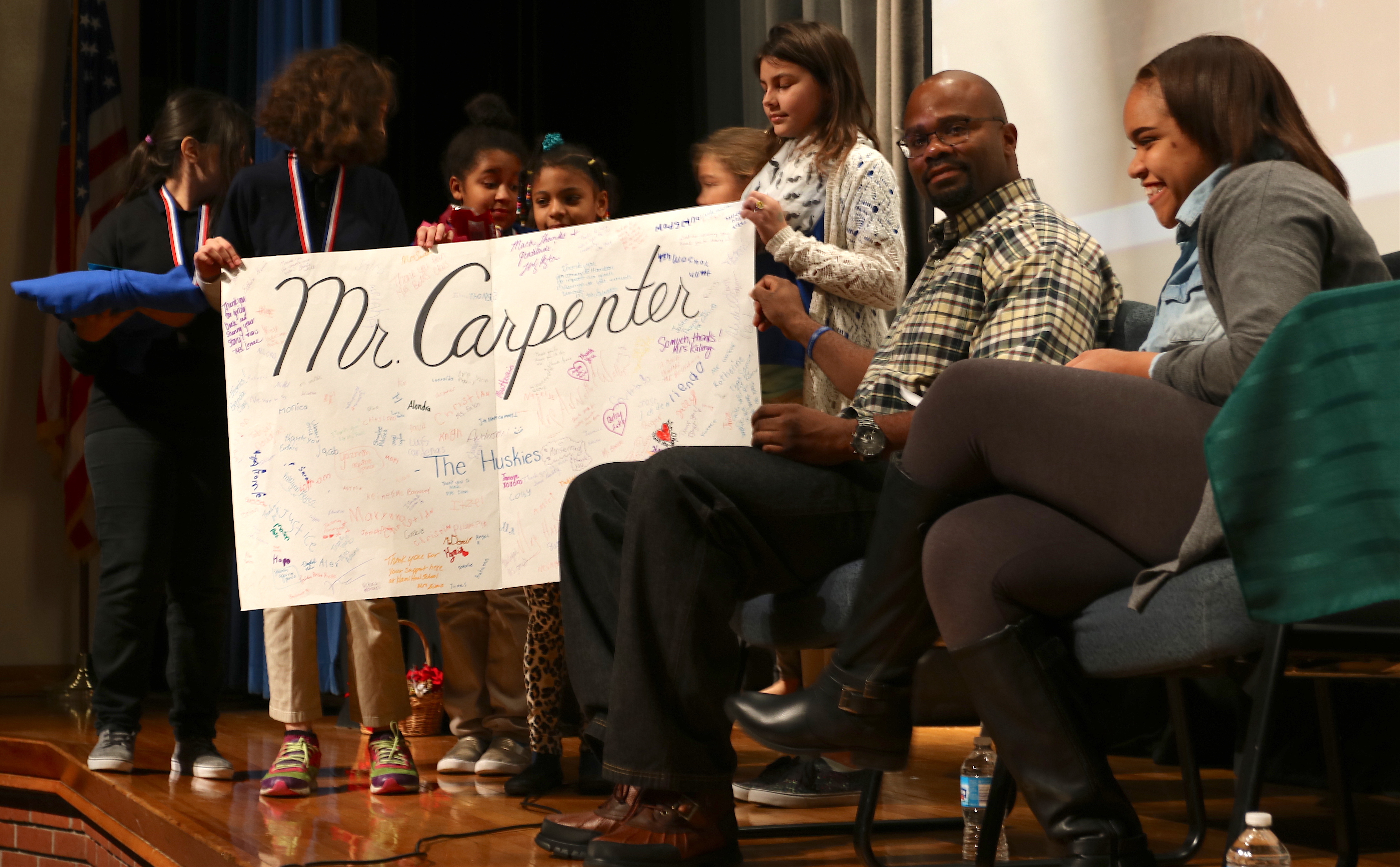 Students at Hamilton Elementary present De'Marchoe Carpenter with a "Thank you" card on Dec. 20.